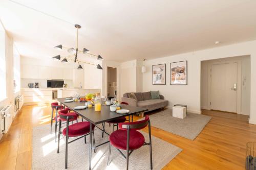 a kitchen and living room with a table and red chairs at Perfect 3 bedroom apartment in the heart of CPH in Copenhagen