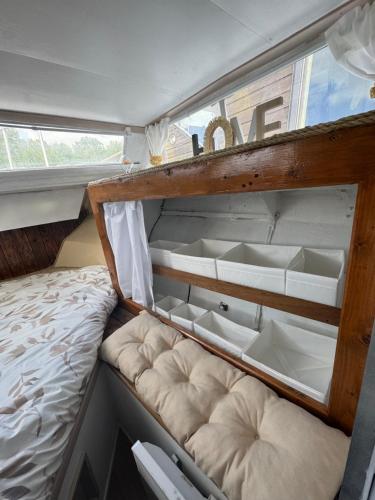a bed in a small room with white dishes at Cocon sur l eau in Montargis