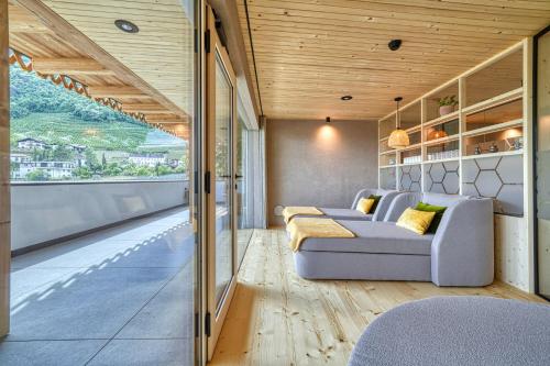a living room with a couch and a large window at Eco Bnb & Apartments Bründlerhof in Marlengo