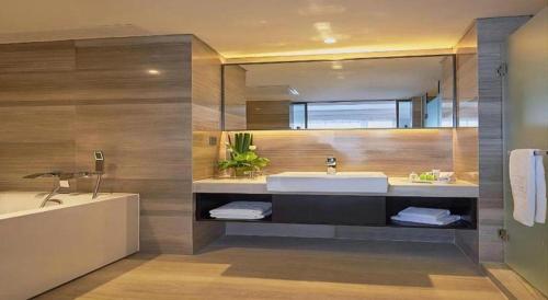 a bathroom with a tub and a sink and a bath tub at NH Shijiazhuang Financial Center in Shijiazhuang