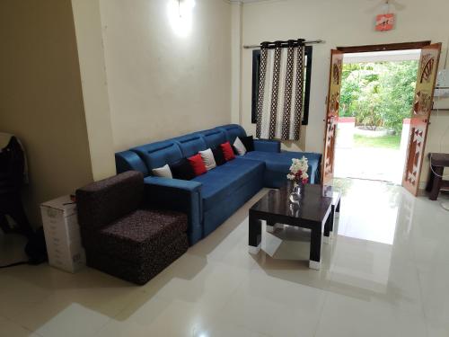 a blue couch and a chair in a living room at Krishna Villa in Vangani