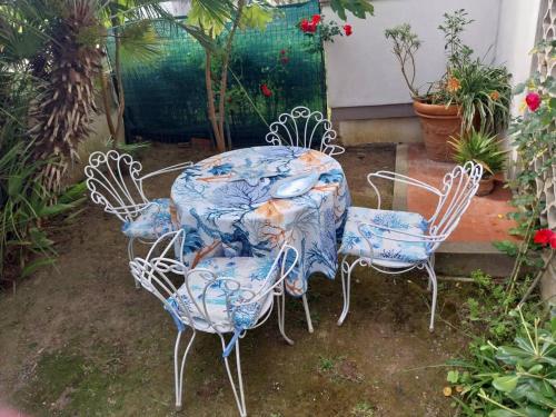 a table and two chairs sitting in a yard at Grande Appartamento in Villa con 2 camere, terrazze, giardino, barbecue e posto auto privato Tutti spazi uso esclusivo in Cecina