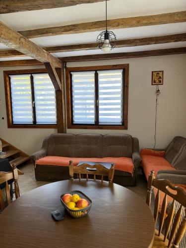 a living room with a table and a couch at Kuća ispod Rajca in Slavkovica