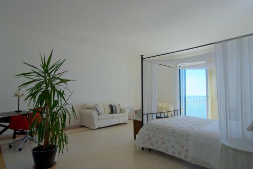 a bedroom with a bed and a couch and a plant at Residenza D'epoca 1861 in Santa Maria di Castellabate