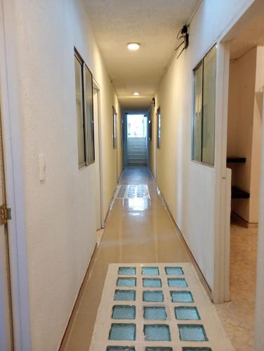 a long hallway with blue tiles on the floor at Hotel Aerocafe Pereira in Pereira