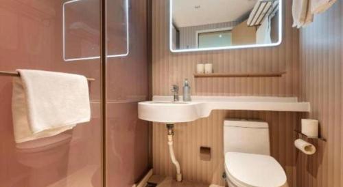 a bathroom with a sink and a toilet and a mirror at Magnotel Shanghai Maglev Station in Shanghai