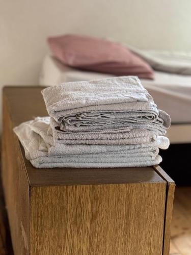 a stack of towels on a wooden box next to a bed at Kuća ispod Rajca in Slavkovica