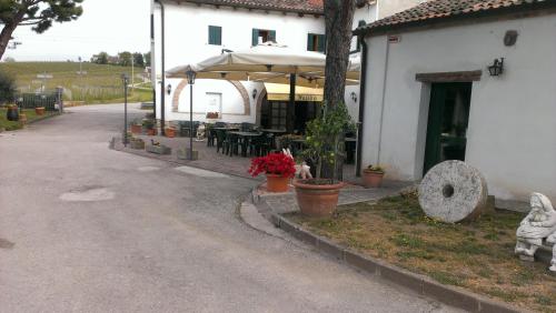 a patio with an umbrella and tables and chairs at Il Feudo in Vo Euganeo