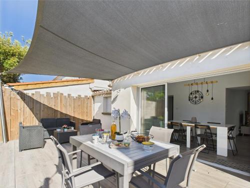 d'une terrasse avec une table blanche et des chaises. dans l'établissement Les Sables d'Olonne, maison avec jardin pour 6, à Les Sables-dʼOlonne