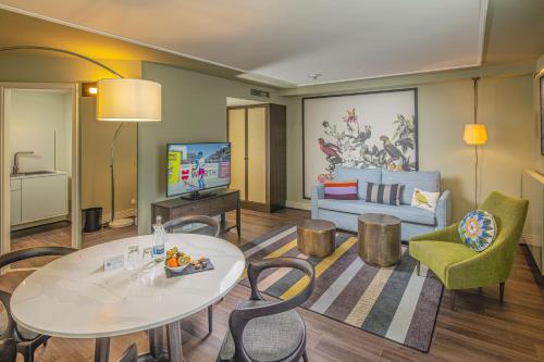a living room with a couch and a table and chairs at Hotel Erbprinz - Gourmet & Spa in Ettlingen