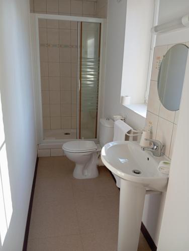 a white bathroom with a toilet and a sink at Le relais du Perche in Les Croix Chemins