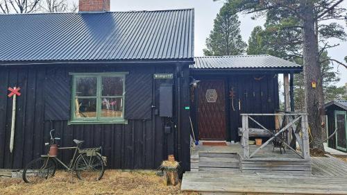 a black house with a bicycle parked outside of it at Messlingen 310 in Funäsdalen
