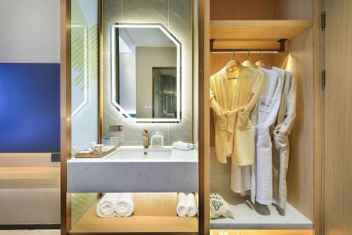 a bathroom with a sink and a mirror at Yangshuo CheerMay Hotel in Yangshuo