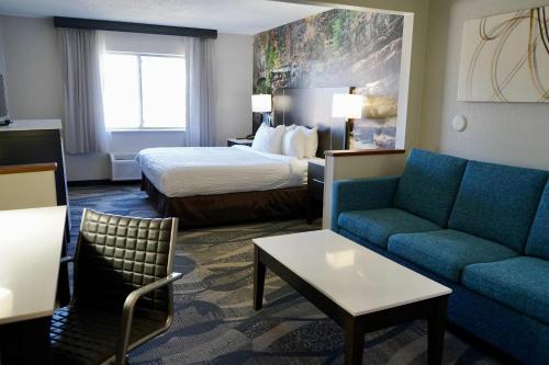 a hotel room with a bed and a couch at Clarion Inn Fairborn - Dayton near Wright Patterson in Fairborn
