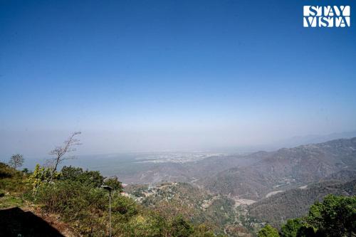 a view of a valley from the top of a mountain at StayVista at Echoes of Ease with Bonfire & WiFi in Rishīkesh