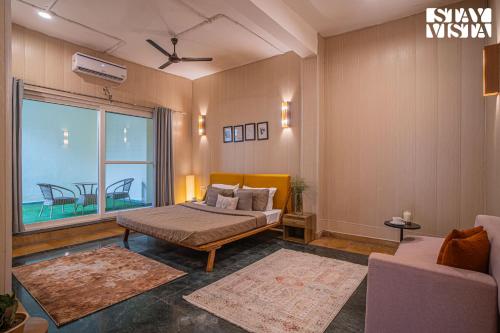 a bedroom with a bed and a large window at StayVista at Echoes of Ease with Bonfire & WiFi in Rishīkesh