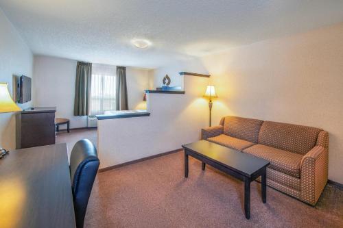 a hotel room with a couch and a table at Quality Inn & Suites in Lethbridge