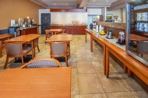 a restaurant with wooden tables and chairs and a counter at Quality Inn & Suites in Lethbridge