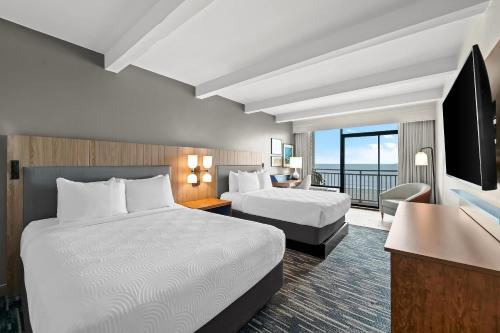 a hotel room with two beds and a television at Country Inn & Suites by Radisson, Virginia Beach Oceanfront , VA in Virginia Beach