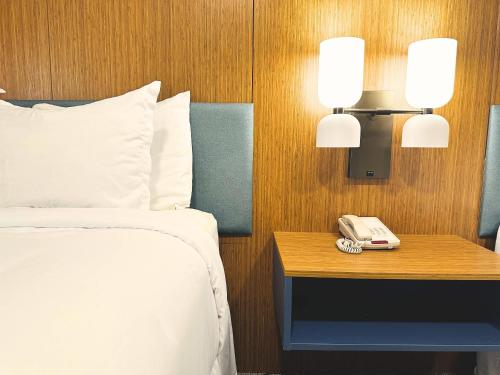 a hotel room with a bed and a phone on a table at Country Inn & Suites by Radisson, Canton near Hall of Fame in Canton