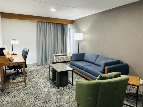 a living room with a blue couch in a hotel room at Country Inn & Suites by Radisson, Canton near Hall of Fame in Canton