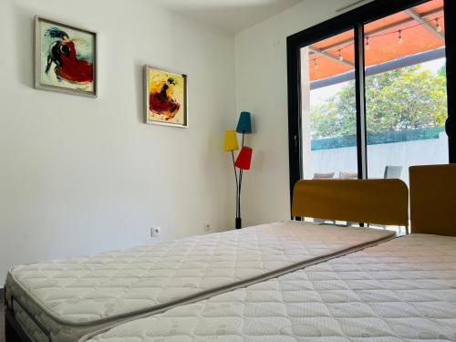 une chambre avec un grand lit et une fenêtre dans l'établissement Maison 3 chambres proche de la mer, à La Ciotat