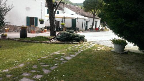 a yard with a house and a house with a tree at Il Feudo in Vo Euganeo