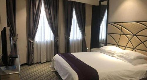 a bedroom with a large bed and two windows at New Century Manju Hotel Shanghai New International Expo Center in Shanghai
