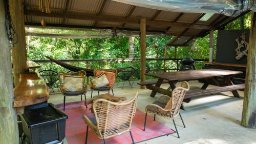 a patio with a table and chairs and a stove at Noah Creek Eco Huts in Cape Tribulation