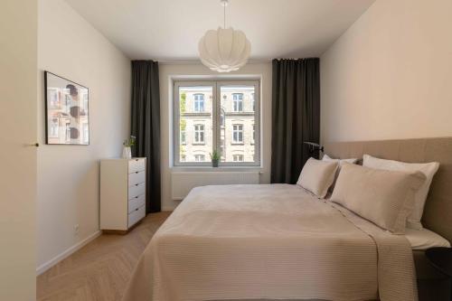a bedroom with a large bed and a window at Newly Renovated 2BR with Balcony in Copenhagen