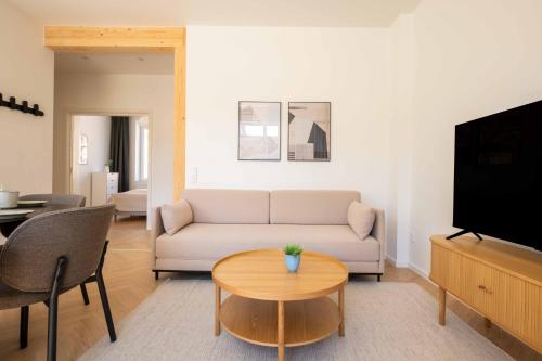 a living room with a couch and a table at Newly Renovated 2BR with Balcony in Copenhagen