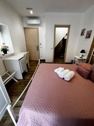 a bedroom with a bed with two towels on it at Oltremare in Cefalù