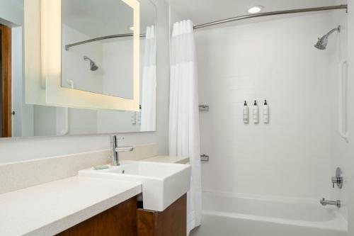 a white bathroom with a sink and a shower at SpringHill Suites by Marriott Charleston Mount Pleasant in Charleston