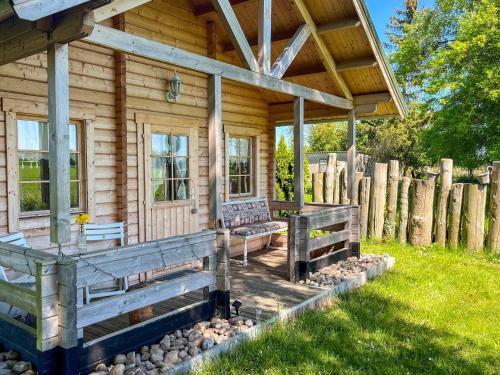 a wooden cabin with a porch and benches outside at Tiny Häuschen Land-Idyll in Neuhof