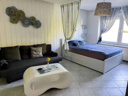 a bedroom with a bed and a couch and a table at Ferienwohnung Wohlfühl-Anker in Neuhof