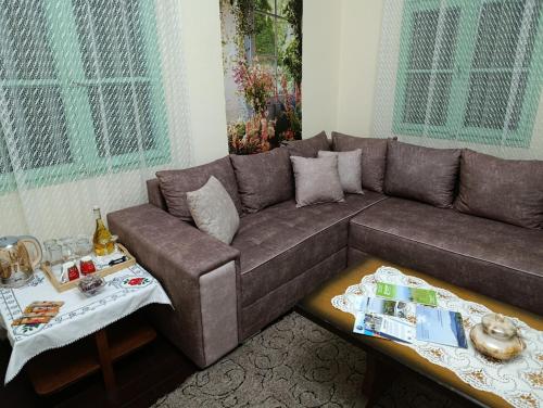 a living room with a brown couch and a table at Vila Jagoda in Bojnik