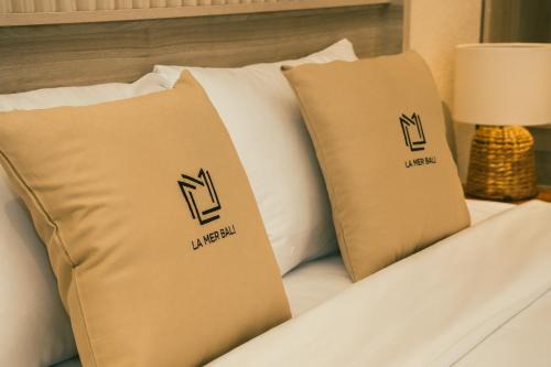a bed with two pillows on top of it at La Mer Bali Mui Ne in Phan Thiet