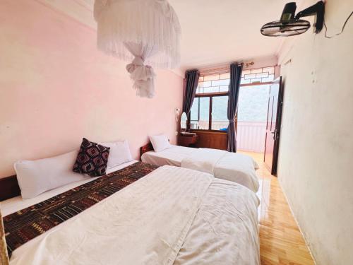 two beds sitting in a room with windows at Ba Be Lake View Homestay in An Ma