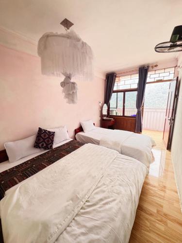 two beds in a hotel room with white sheets at Ba Be Lake View Homestay in An Ma