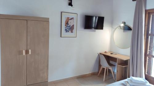 a bedroom with a desk and a mirror at Villa Anna Maria in Agia Paraskevi
