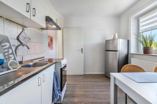 a kitchen with a sink and a refrigerator at Neue ruhige Ferienwohnung in Klein Wittensee