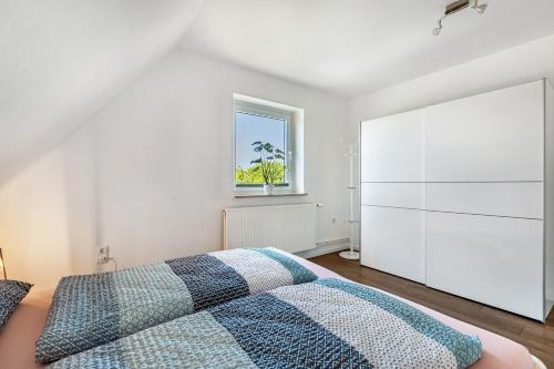 a bedroom with a bed and a window at Neue ruhige Ferienwohnung in Klein Wittensee