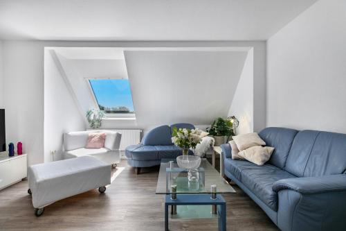 a living room with a blue couch and a table at Neue ruhige Ferienwohnung in Klein Wittensee
