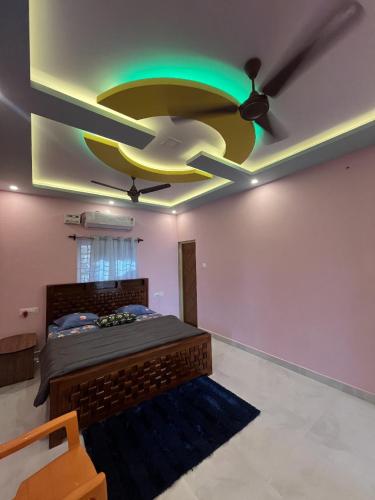 a bedroom with a ceiling fan and a bed at Rest & Relax Resort in Yelagiri