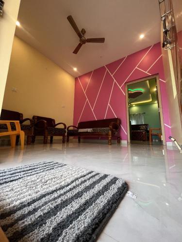 a room with a black rug and a pink wall at Rest & Relax Resort in Yelagiri