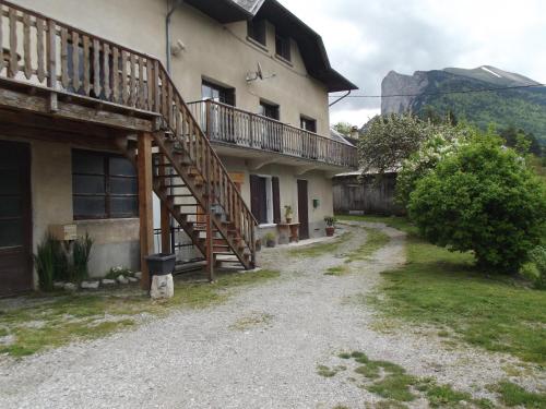 a house with a wooden staircase on the side of it at Le Playon, classification 3 étoiles in Lus-la-Croix-Haute