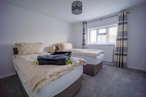 ein Schlafzimmer mit 2 Betten und einem Koffer auf dem Bett in der Unterkunft Artisan Sanctuary in Lincoln