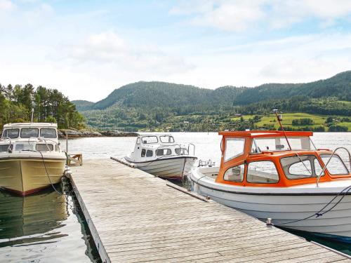 three boats are docked at a dock in the water at 8 person holiday home in VÅGLAND-By Traum in Vågland
