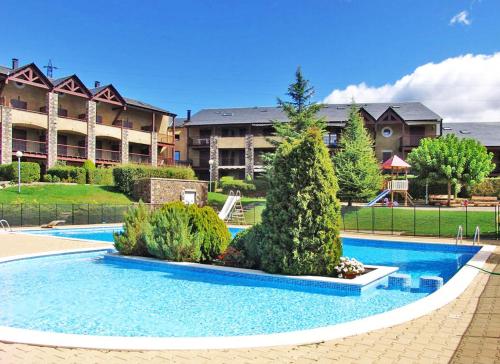 une piscine en face d'un grand bâtiment dans l'établissement El refugio I, à Caldégas