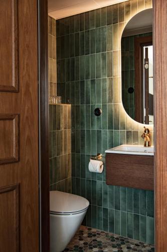 a bathroom with a sink and a toilet and a mirror at Åhus Gästgivaregård in Åhus
